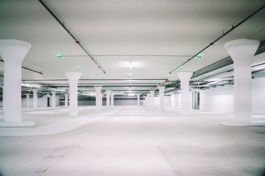 empty white concrete pillared parking lot epoxy flooring contractor