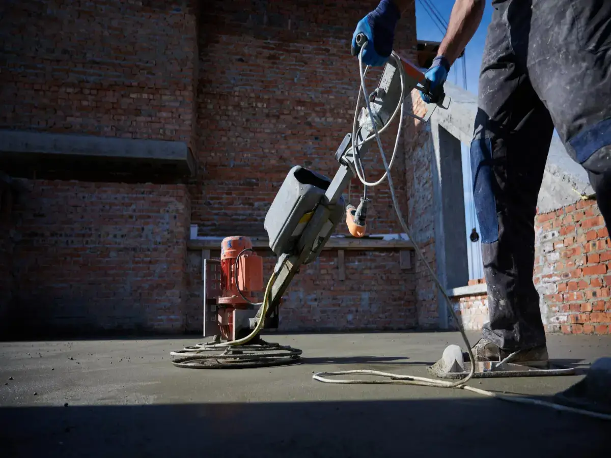 man uses concrete polishing machine local epoxy flooring contractors
